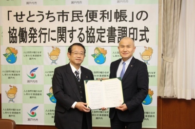 協定書を手にする村田社長（写真左）と武久市長（写真右）