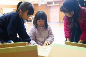 段ボールベッドを組み立てる子どもたち